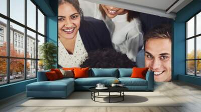 Diverse group of creative colleagues from above looking excited, happy or motivated and ready to take startup business to the top. Portrait of smiling, happy and cheerful office team standing united Wall mural