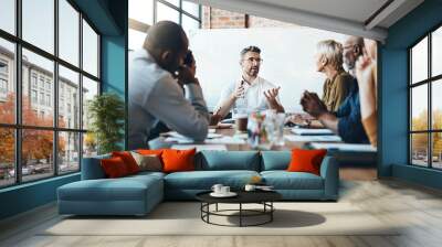 Debating before reaching a decision. Shot of a businessman leading a meeting in the boardroom. Wall mural