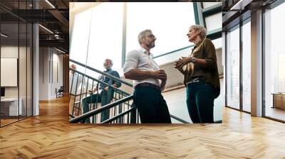 Great ideas come from casual conversations. Shot of two businesspeople talking to each other while standing on a stairwell. Wall mural