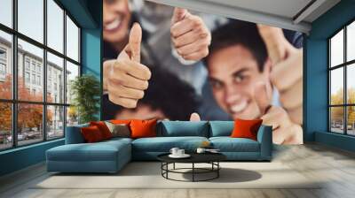 Thumbs up from a happy business team excited about the success they achieve together at work. Overhead view diverse group of corporate people excited by success and give approval to winning Wall mural