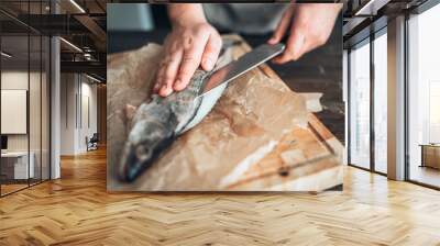 chef hands with knife cut up fish on cutting board Wall mural