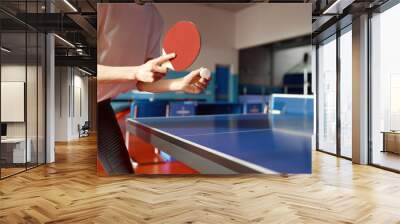 Closeup view of adult woman playing table tennis in gym Wall mural