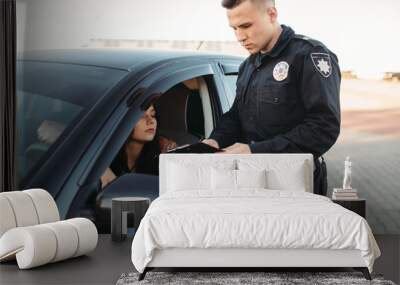 Cop in uniform checks license of female driver Wall mural