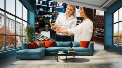 Cosmetician at counter and woman, cosmetics store Wall mural