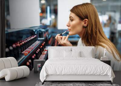 Female customer testing lip liner in make-up shop Wall mural