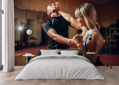 Female person on self-defense workout with trainer Wall mural