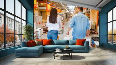 Happy buyers with a cart in hardware store Wall mural