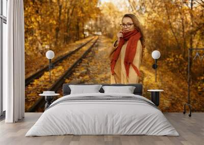 Happy young woman under autumn sun light Wall mural