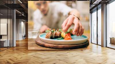 Male chef cooking sushi rolls, japanese food Wall mural