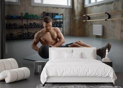 Man doing fitness workout, practicing abs exercise with med ball in gym Wall mural