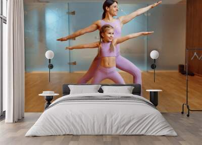 Mother and daughter doing exercise in gym Wall mural