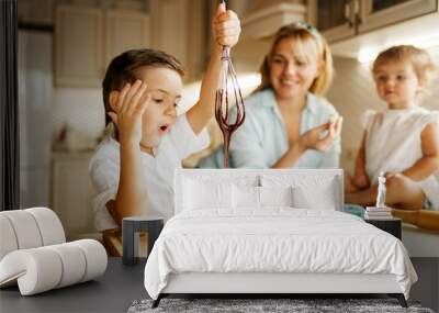 Mother and her kids tastes melted chocolate Wall mural