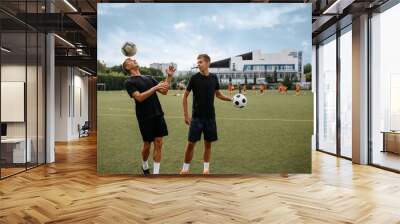 Soccer players training with balls on the field Wall mural