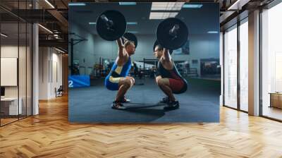 two male weightlifters doing squats with barbells Wall mural