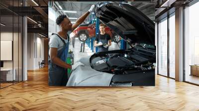 Two male workers inspects engine, car service Wall mural