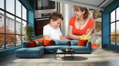 Mother and son preparing lunch and smiles. Cutting red pepper Wall mural