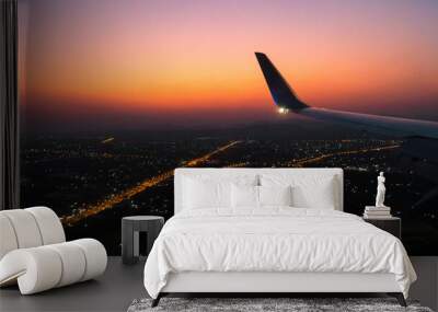 aircraft wing in the sky with sunset sky and city light background,fly to travel concept,romantic in the air,airplane wing with earth background. Wall mural