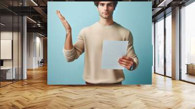 image of a man wearing casual attire showcasing a document with his right hand, man holding a paper  Wall mural