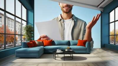 image of a man wearing casual attire showcasing a document with his right hand, man holding a paper  Wall mural