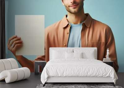 image of a man wearing casual attire showcasing a document with his right hand, man holding a paper in his hand Wall mural