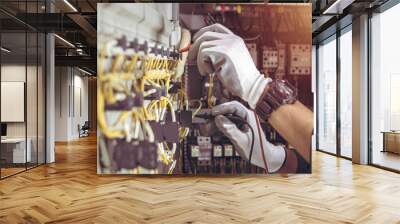 Electrician engineer tests electrical installations and wires on relay protection system. Wall mural