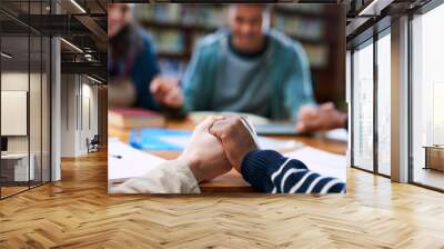 Students, people or holding hands in prayer in school for blessings, grace or guidance in library. Closeup, friends and hope with spirituality for thanks, college or teamwork in study group for exams Wall mural