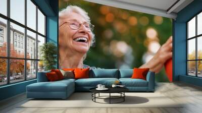 An elderly person enjoying a game of basketball outdoors with an orange ball, shown during a warm, golden sunset, emphasizing vitality and joy. Wall mural