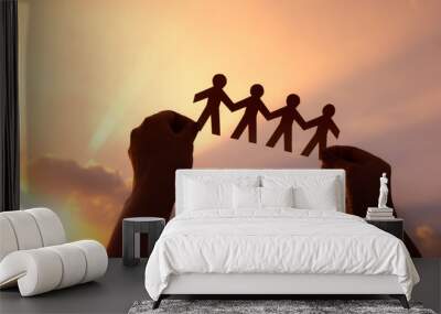 Teamwork and relations concept. woman holding human paper chains at sunrise. People are connected. Concept of human role.  teamwork, family home, society, social network, and people Wall mural