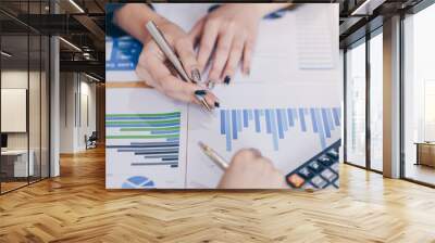 Businesswoman pointing pen on business document at meeting room.Discussion and analysis data charts and graphs showing the results at meeting. Wall mural