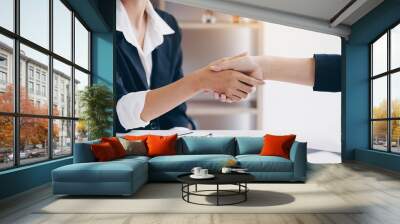 Businesswoman shaking hand for a complete business deal together in meeting room.Teamwork,Partnership and Dealership concept. Wall mural