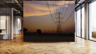 Light towers and high-voltage lines with sky on sunset. Wall mural