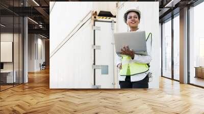 Black foreman woman worker working checking at Container cargo harbor holding laptop computer to loading containers. African dock female staff business Logistics import export shipping concept. Wall mural