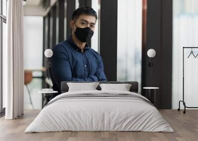 Business asian man wearing protection face mask standing near window in office. Wall mural