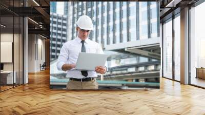 Civil engineering using laptop while working on building construction site. Wall mural