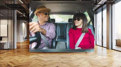 Happy moment couple asian man and woman sitting in car. Enjoying travel concept. Wall mural