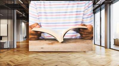 Young asian man reading book. Wall mural