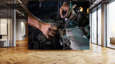 Repairman Working with dirty hands and tools fixing car engine at service shop. Wall mural