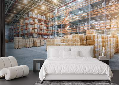 Large industrial warehouse with high racks. In the foreground are a lot of cardboard boxes. Wall mural