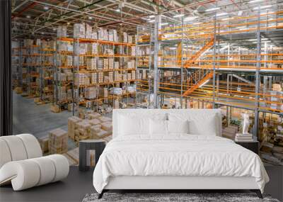 Large industrial warehouse. Tall racks are completely filled with boxes and containers. Wall mural