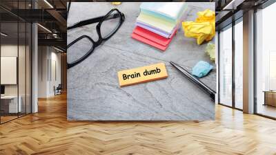 Brain Dump, two words were written on the post-it note on the wooden table, with a pen, crumpled papers, and eyeglasses. Business and in-discussion concept Wall mural