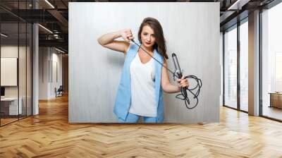 Professional stylist woman holding curling iron in salon. Wall mural