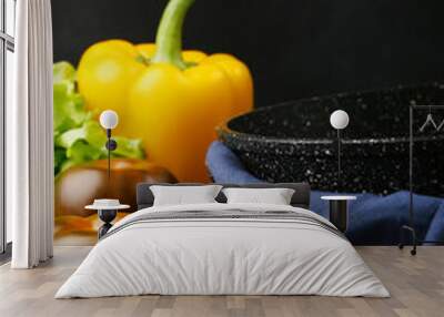 empty pan with ingredients. cast iron pan and vegetables on black metal culinary background Wall mural