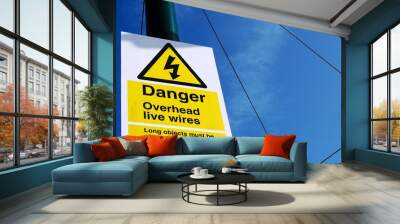 UK sign Danger. Overhead Live Wires against a blue cloudy sky. Wall mural