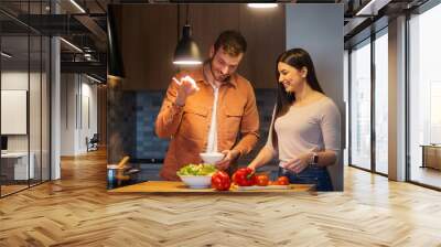 Couple enjoying in kitchen,preparing salad Wall mural