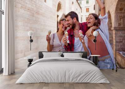 Group of happy tourist eating ice cream in a town Wall mural