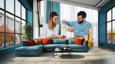 Happy young love couple have breakfast at home Wall mural