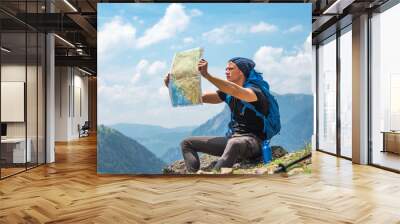 Male handsome hiker using map to navigate in nature Wall mural