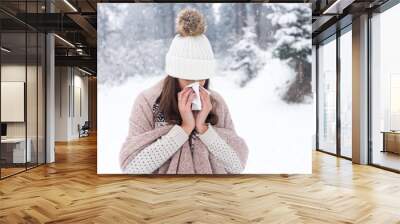 Woman uses a handkerchief at winter day Wall mural