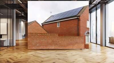 Solar photovoltaic panels mounted on a tiled new familiy houses roof, England Wall mural