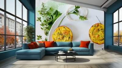 Savoury cheese muffins with fresh herbs on white plate Wall mural